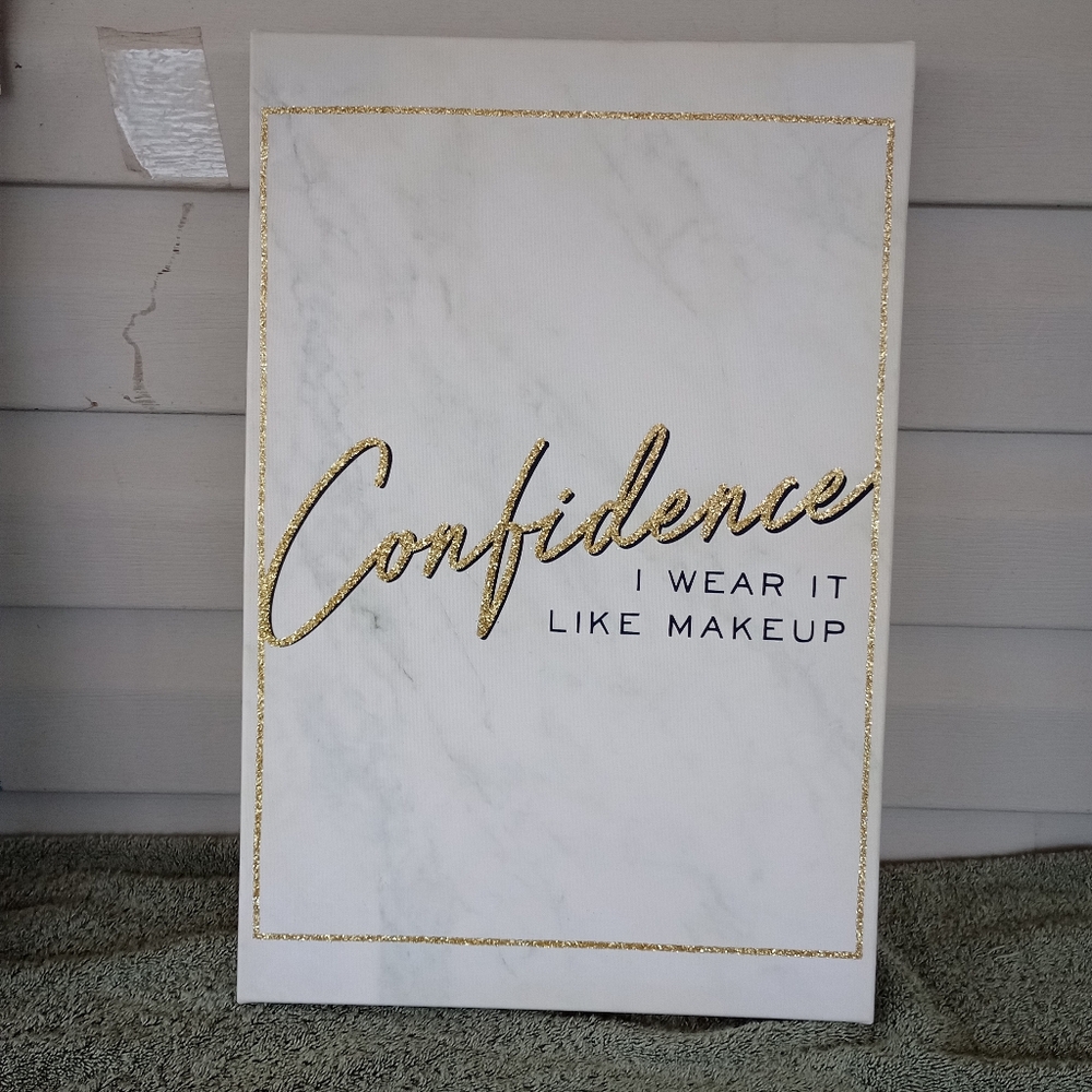 BEBE "Confidence I wear it like makeup" wall decor.